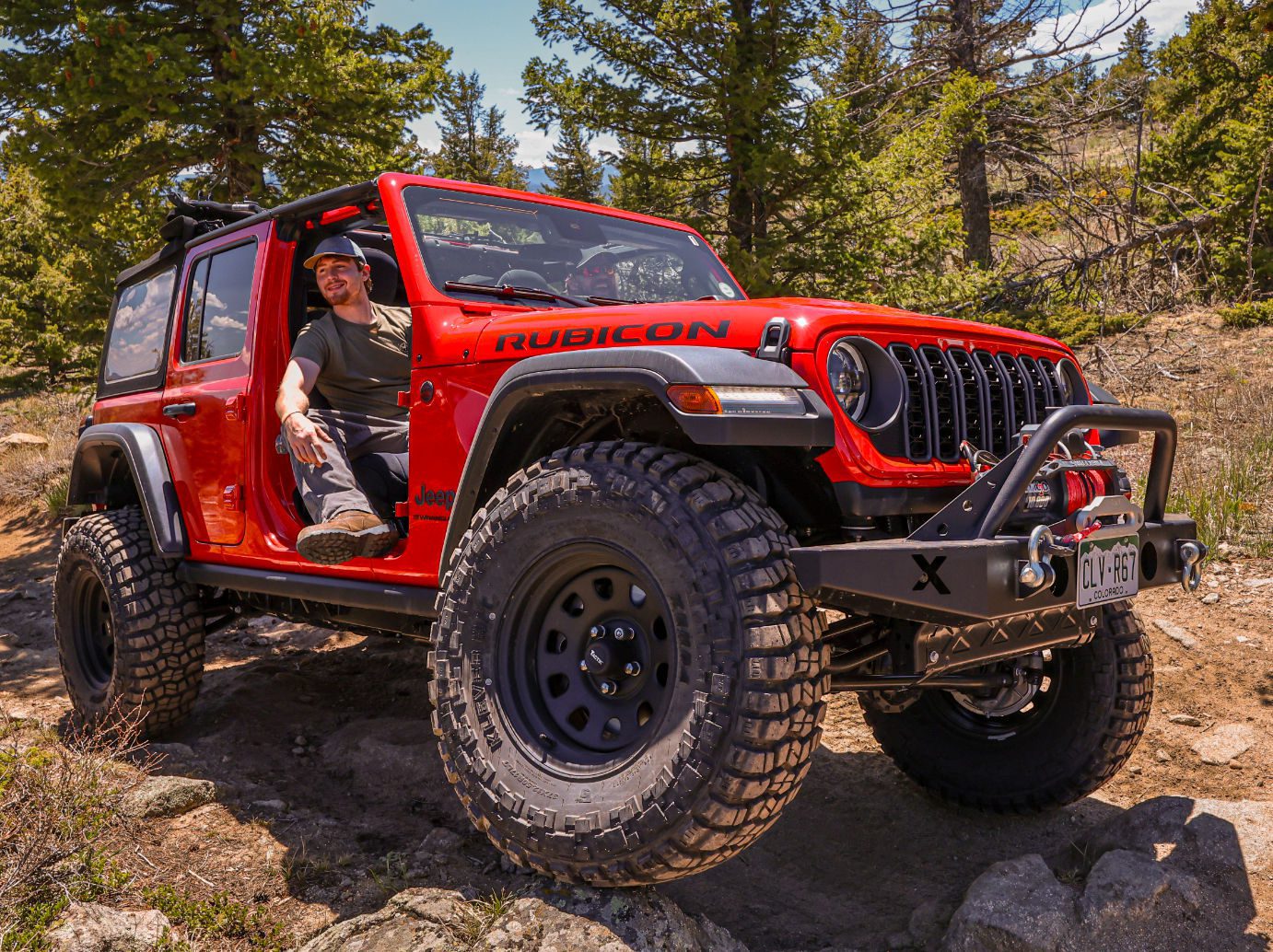 Backbone Adventures - Red Jeep high atop a hill.